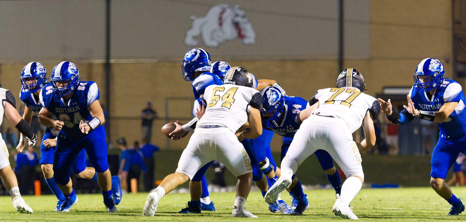The Quitman offensive line clears a path. [view more action and buy Bulldogs prints]